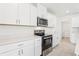 Bright kitchen featuring stainless steel appliances and white cabinets and countertops, oven and microwave at 3213 Viceroy Ct, Poinciana, FL 34759