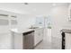 Bright kitchen with stainless steel dishwasher, white cabinets, large island with sink, open to living space at 3213 Viceroy Ct, Poinciana, FL 34759