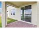 Covered patio with sliding glass doors and a brick-paved floor overlooking a tranquil pond at 3213 Viceroy Ct, Poinciana, FL 34759