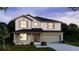 Charming two-story home with neutral colors, manicured lawn, and a two-car garage at dusk at 3222 Viceroy Ct, Kissimmee, FL 34759