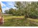Spacious backyard with lush green grass, mature trees, and a partial view of the fence line at 3783 Moon Dancer Pl, St Cloud, FL 34772