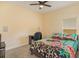 Cozy bedroom with a ceiling fan, a desk, and a patterned bedspread at 3783 Moon Dancer Pl, St Cloud, FL 34772