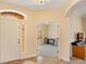 Inviting foyer with tiled flooring, an arched doorway, and access to a sunlit home office at 3783 Moon Dancer Pl, St Cloud, FL 34772
