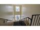 A stairwell with stairs leading up to the floor above with a large window on both landings at 4161 Versailles Dr # 4161G, Orlando, FL 32808
