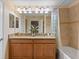 Bright bathroom featuring a double vanity with granite countertops and a shower-tub combo at 4895 Clock Tower Dr, Kissimmee, FL 34746