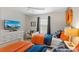 Nautical-themed bedroom featuring two twin beds, each adorned with vibrant orange and blue bedding at 4895 Clock Tower Dr, Kissimmee, FL 34746