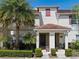 Inviting two-story townhome with a tile roof, lush landscaping, and a charming covered entryway at 4895 Clock Tower Dr, Kissimmee, FL 34746