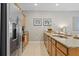 Spacious kitchen with stainless steel refrigerator and granite counters extending into adjacent living space at 4895 Clock Tower Dr, Kissimmee, FL 34746