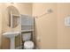 Cozy half-bathroom with pedestal sink, toilet, and a cabinet for storage at 5252 Hidden Cypress Ln, Oviedo, FL 32765