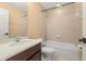 Bright bathroom featuring a shower-tub combo with tiled walls, dark wood cabinets, and modern fixtures at 5252 Hidden Cypress Ln, Oviedo, FL 32765