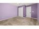 Carpeted bedroom with a closet and door, painted in a modern purple at 5252 Hidden Cypress Ln, Oviedo, FL 32765