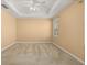 Spacious bedroom with a ceiling fan, plush carpet, and a tray ceiling at 5252 Hidden Cypress Ln, Oviedo, FL 32765