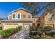 Charming two-story townhome featuring a two-car garage, beautifully landscaped yard, and colorful exterior at 5252 Hidden Cypress Ln, Oviedo, FL 32765