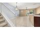 Bright open-concept living room with staircase, neutral walls, tile flooring and modern light fixtures at 5252 Hidden Cypress Ln, Oviedo, FL 32765