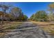 View of the paved neighborhood street lined with trees and green spaces at 5252 Hidden Cypress Ln, Oviedo, FL 32765