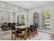 Bright dining room with a large mirror accent wall and arched windows overlooking the yard at 5337 Foxshire Ct, Orlando, FL 32819