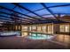 Screened-in pool at dusk featuring an attached jacuzzi and lots of room for entertaining at 5337 Foxshire Ct, Orlando, FL 32819