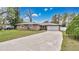 Charming single-story home featuring a long driveway and attached two-car garage at 5410 S Pine Hill Cir, Orlando, FL 32808