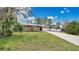 Charming single-story home featuring a long driveway and attached two-car garage at 5410 S Pine Hill Cir, Orlando, FL 32808