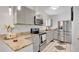 Well-lit kitchen with stainless steel appliances, granite countertops, and light gray cabinets at 5410 S Pine Hill Cir, Orlando, FL 32808