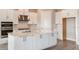 Modern kitchen featuring white cabinets, stainless steel appliances, a central island with marble countertop, and wood-style flooring at 5640 Nevis Ter, Kissimmee, FL 34758