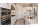 Modern kitchen showcasing stainless steel appliances, white cabinets, a marble countertop island and neutral backsplash tiles at 5640 Nevis Ter, Kissimmee, FL 34758