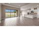 Spacious living area leading to a kitchen, featuring hardwood floors, recessed lighting, and sliding glass doors to the backyard at 5640 Nevis Ter, Kissimmee, FL 34758