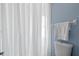 Bathroom with tile surround shower featuring white curtain, toilet, and towel rack at 7507 Pacific Heights Cir, Orlando, FL 32835
