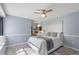 Comfortable bedroom featuring wood-look floors, a ceiling fan, and a view to the en-suite bathroom at 7507 Pacific Heights Cir, Orlando, FL 32835