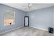 Empty bedroom with wood-look floors and a black framed mirror at 7507 Pacific Heights Cir, Orlando, FL 32835