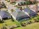 Aerial view of the backyard with the screened-in pool, landscaping, and patio at 8400 Bridgeport Bay Cir, Mount Dora, FL 32757