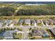 Aerial view of a single-story home, showcasing its location in a quiet neighborhood with lush greenery and mature trees at 8400 Bridgeport Bay Cir, Mount Dora, FL 32757