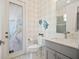 Stylish bathroom with a patterned glass door, gray vanity, and decorative fish accents at 8400 Bridgeport Bay Cir, Mount Dora, FL 32757