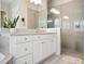 Bathroom featuring a double vanity, step-in shower, neutral tile backsplash, and modern fixtures at 8400 Bridgeport Bay Cir, Mount Dora, FL 32757