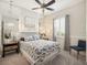 Comfortable bedroom with a blue and white patterned bedspread, mirrored wall, and a stylish ceiling fan at 8400 Bridgeport Bay Cir, Mount Dora, FL 32757