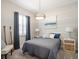 Cozy bedroom featuring a queen bed, nautical decor, and natural light from a window with plantation shutters at 8400 Bridgeport Bay Cir, Mount Dora, FL 32757