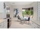 Bright breakfast nook with a glass table, bench seat, and modern decor next to a large window with backyard views at 8400 Bridgeport Bay Cir, Mount Dora, FL 32757