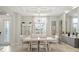 Formal dining room featuring a white table, elegant chandelier, wainscoting, and a decorative cabinet with glass doors at 8400 Bridgeport Bay Cir, Mount Dora, FL 32757