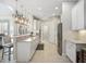 Spacious open kitchen with white cabinets, stainless steel appliances, and a long breakfast bar, perfect for entertaining at 8400 Bridgeport Bay Cir, Mount Dora, FL 32757