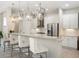 Bright kitchen featuring modern white cabinets, stainless steel appliances, a breakfast bar with seating, and pendant lighting at 8400 Bridgeport Bay Cir, Mount Dora, FL 32757