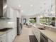 Well-lit kitchen featuring white cabinets, stainless steel appliances, and a breakfast bar overlooking the dining area at 8400 Bridgeport Bay Cir, Mount Dora, FL 32757