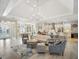 Bright, open living room featuring hardwood floors, neutral furniture, and a stunning chandelier with easy access to the kitchen at 8400 Bridgeport Bay Cir, Mount Dora, FL 32757