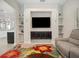 Stylish living room with custom shelving and a gray couch, accented by a vibrant floral rug at 8400 Bridgeport Bay Cir, Mount Dora, FL 32757