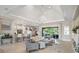 Elegant living room with a tray ceiling, featuring hardwood floors, neutral furniture, and access to an outdoor patio at 8400 Bridgeport Bay Cir, Mount Dora, FL 32757