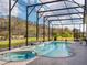 Beautiful screened-in pool and spa with brick pavers and green grass at 8400 Bridgeport Bay Cir, Mount Dora, FL 32757