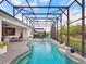 Sparkling pool with a sun shelf, spa, and covered patio with outdoor seating at 8400 Bridgeport Bay Cir, Mount Dora, FL 32757