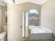 Bright bathroom features a tub with window and a separate shower with a toilet and privacy door at 8603 Primrose Dr, Kissimmee, FL 34747