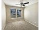 Bedroom with neutral walls, carpet, two windows, and a ceiling fan at 8603 Primrose Dr, Kissimmee, FL 34747