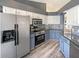 Modern kitchen boasts stainless steel appliances, sleek countertops, and stylish blue and white cabinetry at 8603 Primrose Dr, Kissimmee, FL 34747
