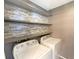 Laundry room equipped with a washer and dryer and decorative wall shelving is ready for laundry day at 8603 Primrose Dr, Kissimmee, FL 34747
